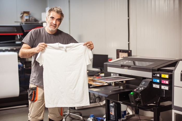 mężczyzna w drukarni trzyma koszulkę